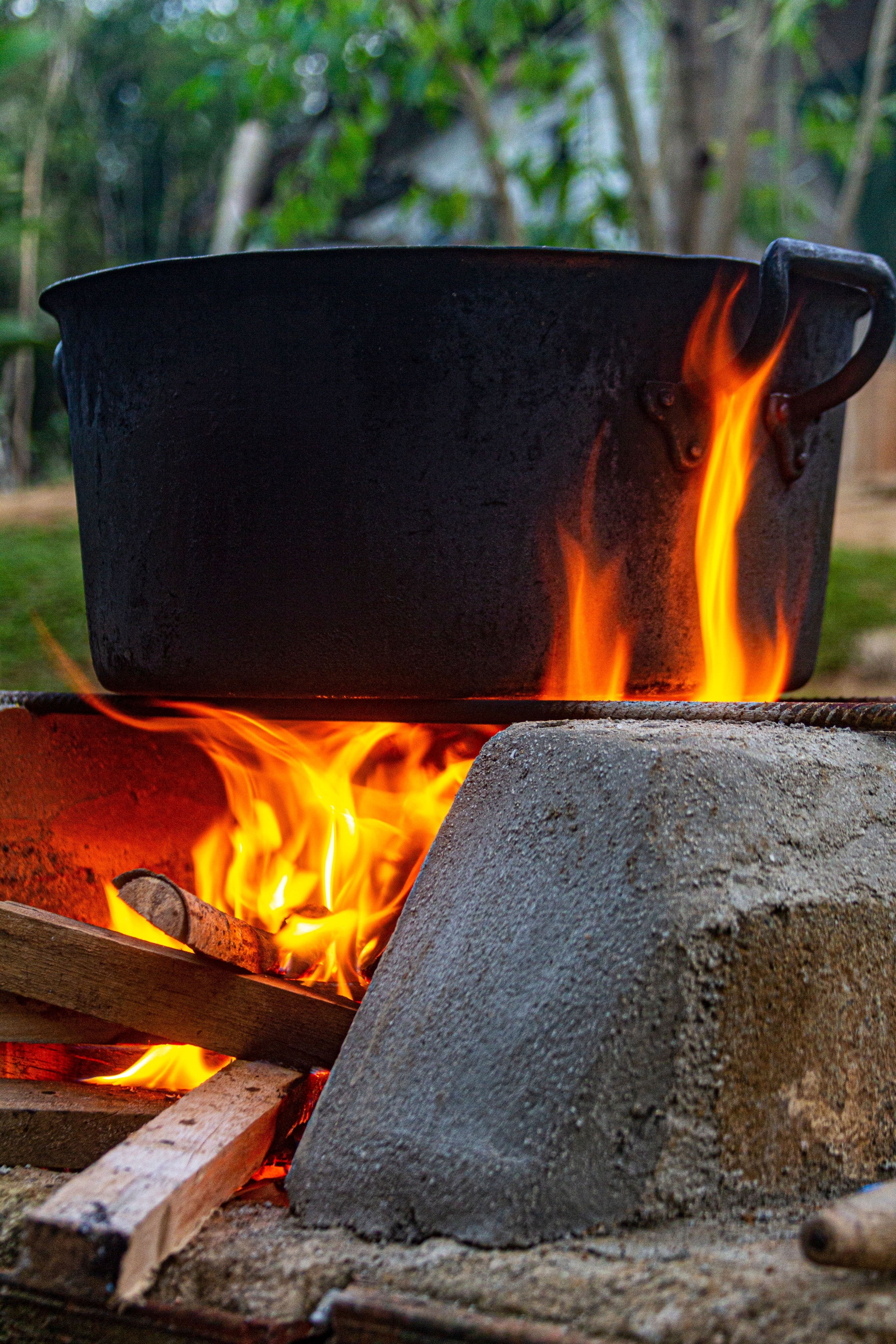 Cast-iron pot cooking over an open wood fire outdoors